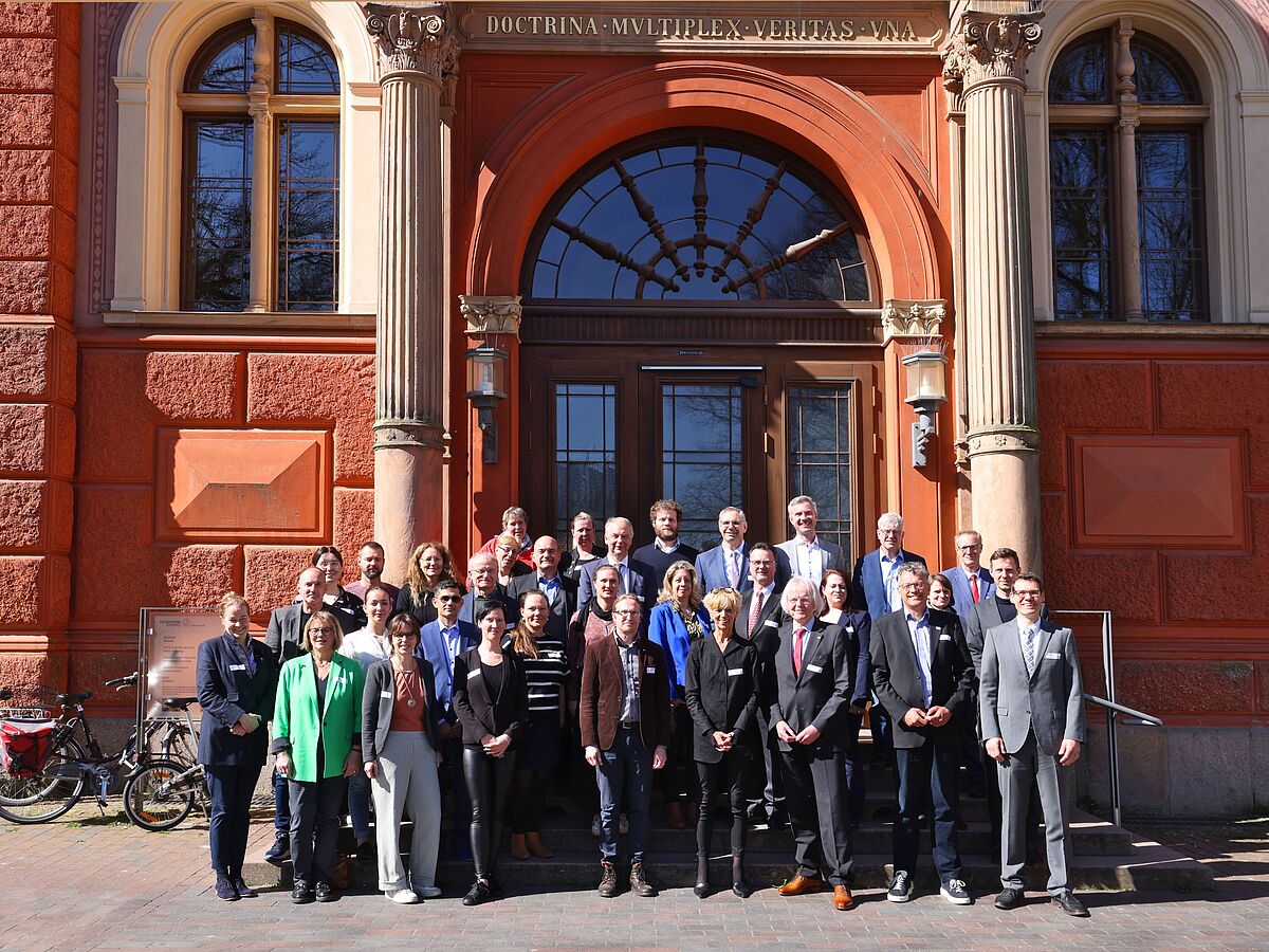 Die Projektpartnerinnen und -partner von "KI-Tierwohl" haben sich hier für ein gemeinsames Gruppenfoto zusammen vor der Universität Rostock aufgestellt. 