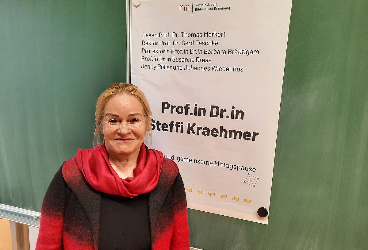 Auf Foto sieht man Steffi Kraehmer vor einer grünen Tafel stehen.