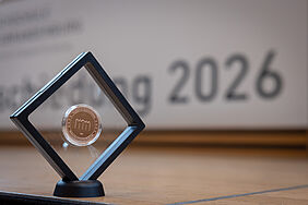 Das Foto zeigt die roségoldene Münze, die für die Verabschiedungsfeier geprägt wurde.