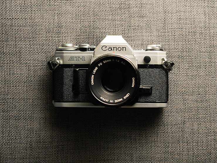 Digitales Bild einer Canon-AT1 Kamera auf grauem Strukturstoff