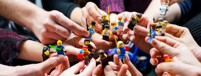 Mehrere Hände halten Lego Star Wars Figuren zusammen